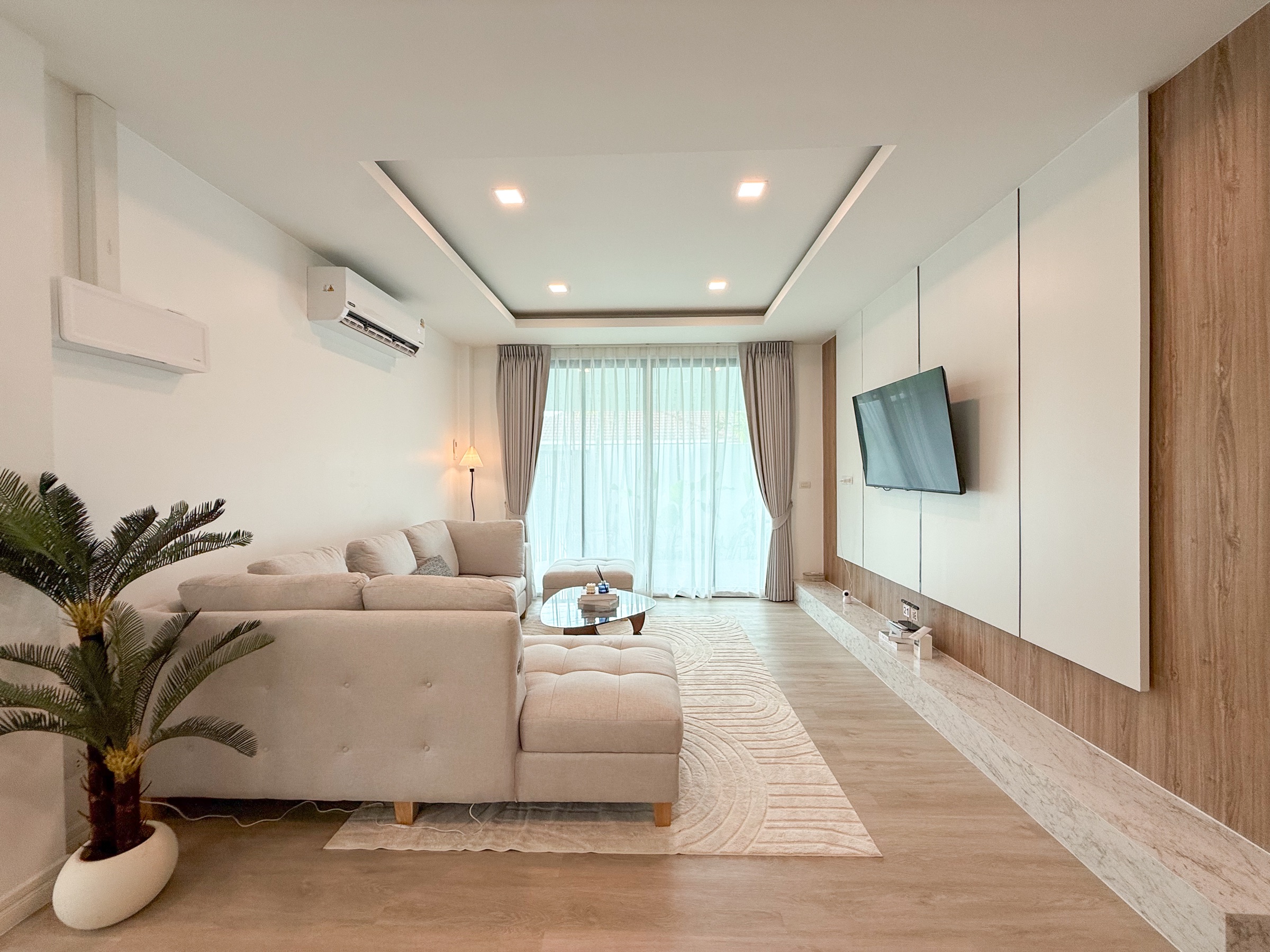 ห้องนั่งเล่นโทนอุ่นพร้อมช่องเปิดสู่สวน